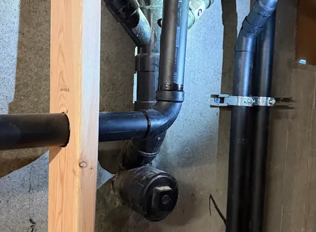 New black drain and vent piping in a basement