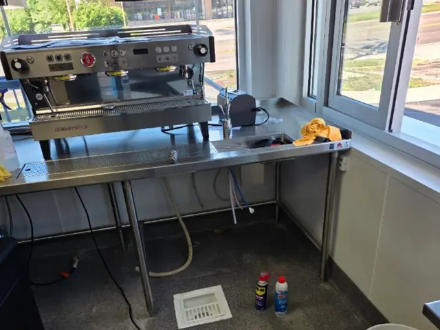 Cafe counter with an espresso machine and a floor drain