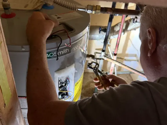 Plumber repairing the wiring on a water heater